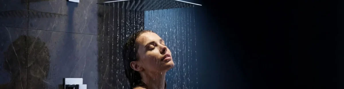Mujer disfrutando de un baño gracias a su grifería de duchas.